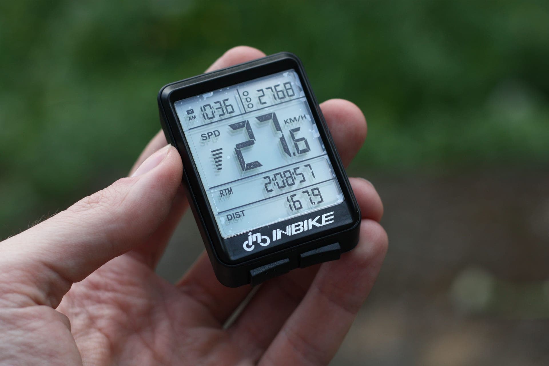 A cyclist reviewing power data on a screen next to an indoor trainer